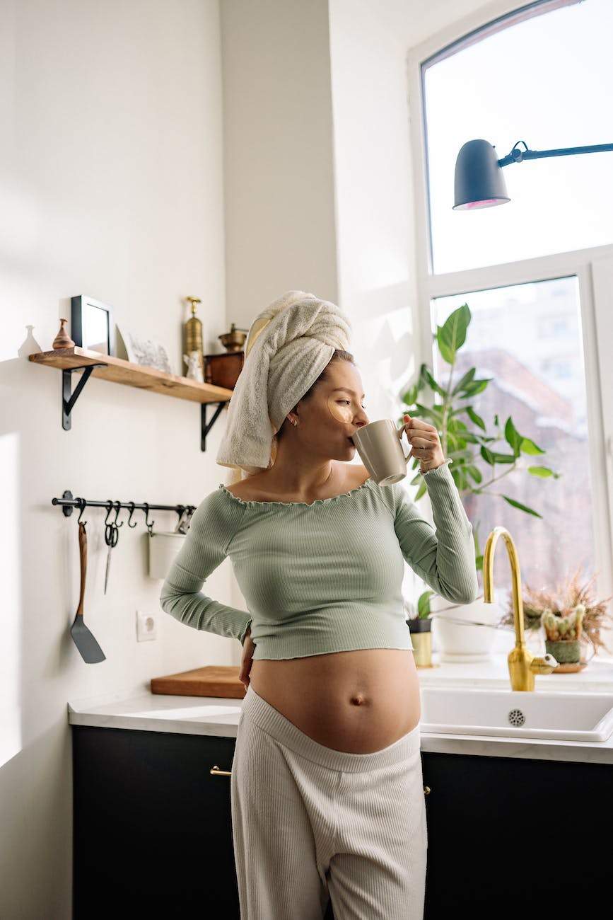 a pregnant woman having a cup of hot drink